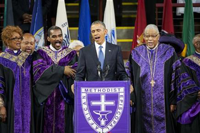 President Barack Obama sings "Amazing Grace" during services honoring the life of Rev. Clementa Pinckney, Friday, June 26, 2015, at the College of Charleston TD Arena in Charleston, S.C.. Pinckney was one of the nine people killed in the shooting at Emanuel AME Church last week in Charleston. (AP Photo/David Goldman)