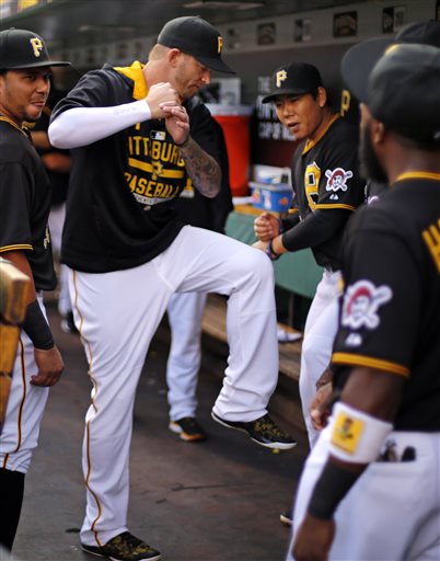 In this June 9, 2015, Pirates starting pitcher A.J. Burnett, left center, imitates the batting stance of teammate Jung Ho Kang, right center, in the dugout before a baseball game against the Milwaukee Brewers in Pittsburgh. There have been plenty of variables during the South Koreans first spring as a big league player. The one constant has been his belief in his own abilities, something that was never in danger of getting lost in translation as the 28-year-old became the first position player to jump directly from the Korean Baseball Organization to the majors. (AP Photo/Gene J. Puskar, File)