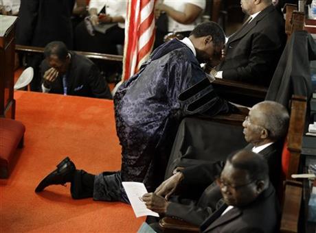 he Rev. Norvel Goff, right, prays at the empty seat of the Rev. Clementa Pinckney at the Emanuel A.M.E. Church four days after a mass shooting that claimed the lives of Pinckney and eight others on Sunday, June 21, 2015, in Charleston, S.C. (AP Photo/David Goldman, Pool)