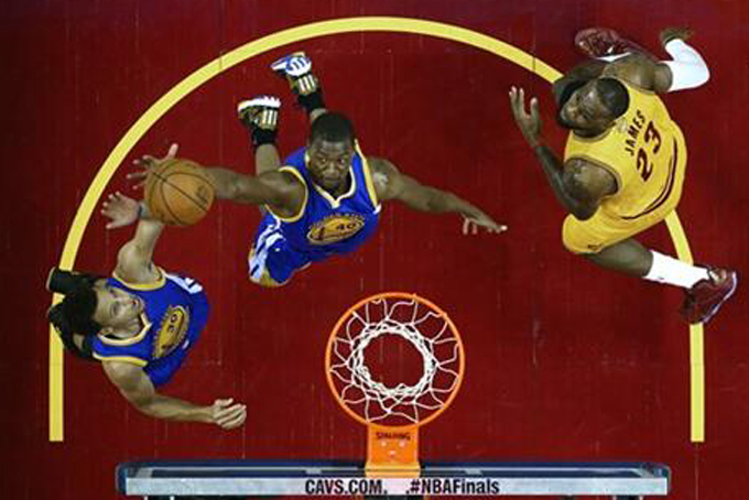 Golden State Warriors guard Stephen Curry (30), left, and teammate forward Harrison Barnes (40) go for a rebound over Cleveland Cavaliers forward LeBron James (23) during the first half of Game 4 of basketball's NBA Finals in Cleveland, Thursday, June 11, 2015. (Ronald Martinez/Pool Photo via AP)