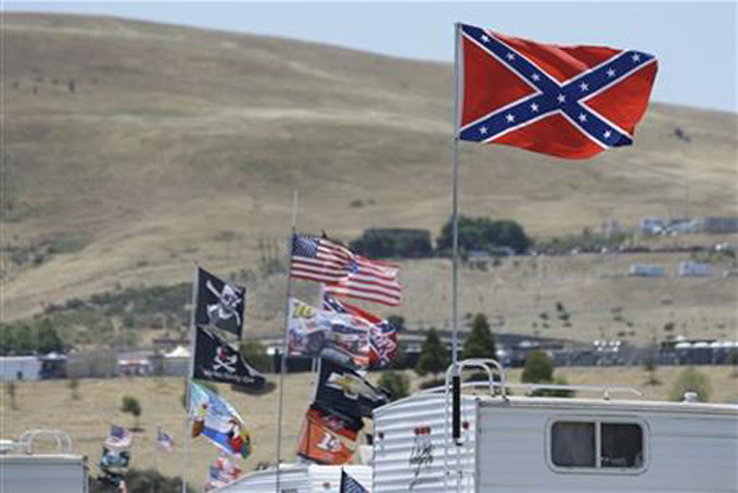 A number of flags, including a Confederate-themed one, fly atop RV's in a campground outside the track during practice for the NASCAR Sprint Cup Series auto race Friday, June 26, 2015, in Sonoma, Calif. (AP Photo/Eric Risberg)