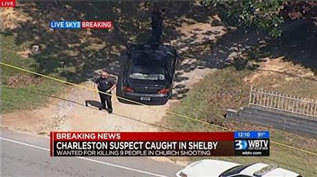 In this image taken from video and released by WBTV, police stand near the vehicle that was driven by Dylann Storm Roof, Thursday, June 18, 2015, in Shelby, N.C. (WBTV via AP) 