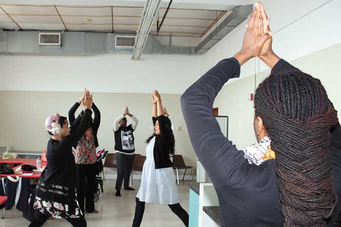 HEALTHY EXERCISE—A Yoga class held by Roopa Singh, wearing the white dress and black sweater. 