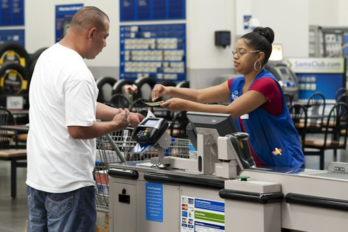 Conquisia Tyler, right, gives change to a customer at Sam's Club in Bentonville, Ark. in June. (Photo: Sarah Bentham, AP)