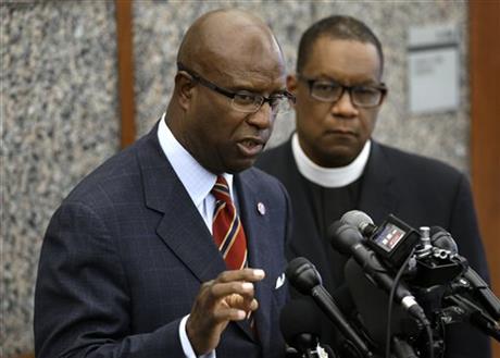 Darnell Williams, head of the Urban League of Eastern Massachusetts, left, speaks with reporters during a news conference as Rev. Mark Scott, of the Azusa Christian Community church, right, looks on, Wednesday, June 3, 2015, at Boston Police Headquarters, in Boston. Boston police said they have video showing Usaama Rahim, a man who was under 24-hour surveillance by terrorism investigators, lunging with a knife at a police officer and an FBI agent before he was shot and killed.(AP Photo/Steven Senne)