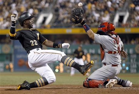 Pittsburgh Pirates' Andrew McCutchen (22) scores from second base on a hit by Jung Ho Kang as the ball gets away from St. Louis Cardinals catcher Yadier Molina during the eighth inning of a baseball game, Saturday, July 11, 2015, in Pittsburgh. (AP Photo/Keith Srakocic)