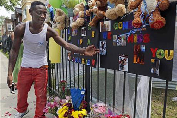 In this July 6, 2015, file photo, Antonio Brown, father of Amari Brown, speaks near a sign honoring his son, in Chicago. Seven-year-old Amari was among three people who were shot and killed overnight during a weekend outbreak of gun-related violence in Chicago. Homicides and shooting incidents in Chicago are up roughly 20 percent from the same period last year. (AP Photo/Christian K. Lee, File)