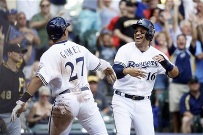 Milwaukee Brewers' Carlos Gomez (27) and Aramis Ramirez celebrate at home after scoring on a hit by Khris Davis during the seventh inning of a baseball game against the Pittsburgh Pirates Sunday, July 19, 2015, in Milwaukee. (AP Photo/Morry Gash)