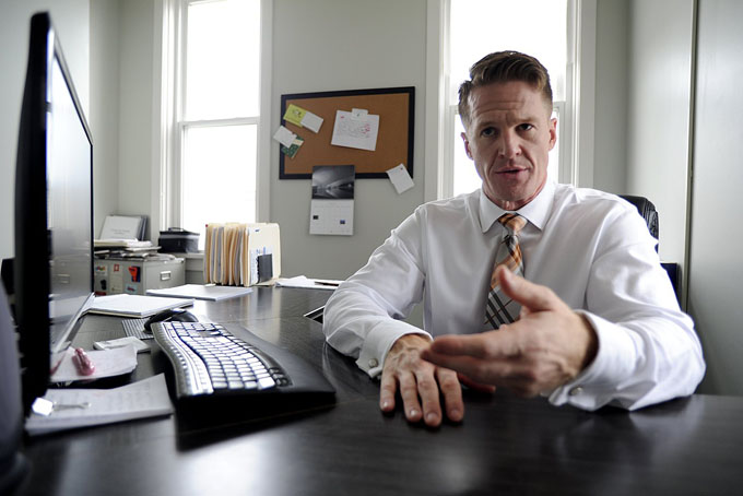 Jason Snyder, three-and-a-half years into recovery, sits in his office at the Consumer Health Coalition in Pittsburgh. He is the organization’s executive director. (Photo by Connor Mulvaney)