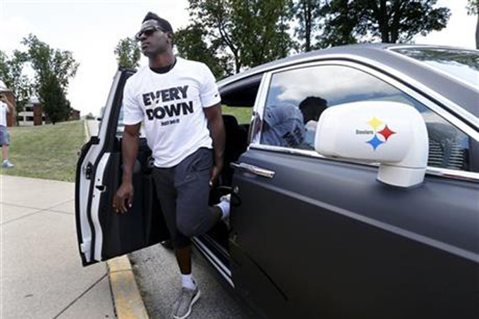 Pittsburgh Steelers wide receiver Antonio Brown gets out of his custom Steelers-themed Rolls Royce as he arrives for NFL football training camp at the team's training facility in Latrobe, Pa., Saturday, July 25, 2015. (AP Photo/Keith Srakocic)