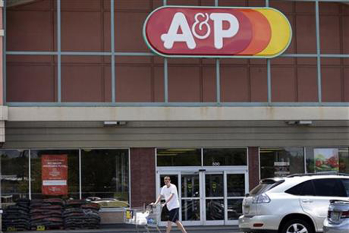 A shopper pushes a cart in front of an A&P supermarket in North Brunswick, N.J., Monday, July 20, 2015. (AP Photo/Mel Evans)