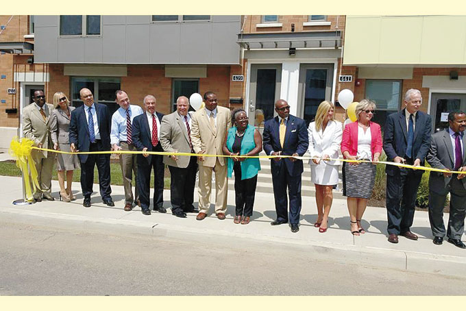 COMMUNITY EVENT—Pastors, investors, developers, politicians, neighbors and friends, all join in the ribbon cutting ceremony for the first phase of the Larimer Pointe affordable housing plan.