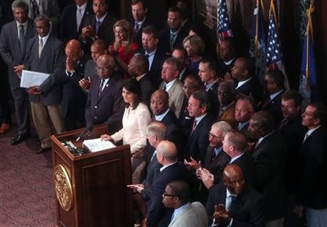  In a Monday, June 22, 2015 file photo, South Carolina Gov. Nikki Haley, center, is applauded during a news conference in the South Carolina State House, in Columbia, S.C. Haley said that the Confederate flag should come down from the grounds of the state capitol, reversing her position on the divisive symbol amid growing calls for it to be removed. (Tim Dominick/The State via AP, File)