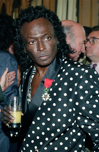 In this July 16, 1991 file photo, jazz great Miles Davis is pictured after receiving the Chevalier de la Legion d'Honneur award medal from the French government in Paris. Davis wasn't even listed in the program book when he appeared for the first time at the Newport Jazz Festival in 1955, but he made his presence felt with a career-reviving performance in an all-star jam session. This year's program book is Miles-centric as the festival, which begins July 31, celebrates the 60th anniversary of the late jazz legend's historic Newport debut.  (AP Photo/Remy de la Mauviniere, File)