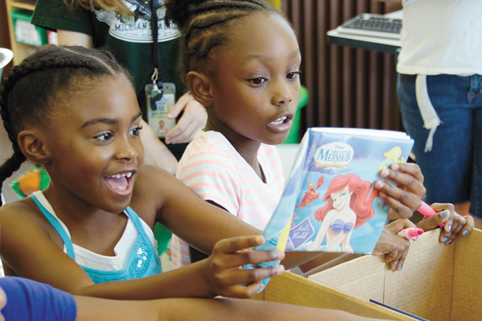 PICK A BOOK—Jace Bell and A’zeria Bates selecting books at the Rankin Christian Center on July 14. The books were collected through a Book Drive hosted by the Allegheny County Department of Human Services. (Photo by Matthew Kruth)
