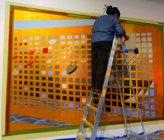 IT'S ALL ABOUT LOVE--Guest artist Ramon Riley finishing his painting "LoveLocks" for the "Wall Paintings" exhibit at SPACE Gallery. (Photo by Shanna Smail)