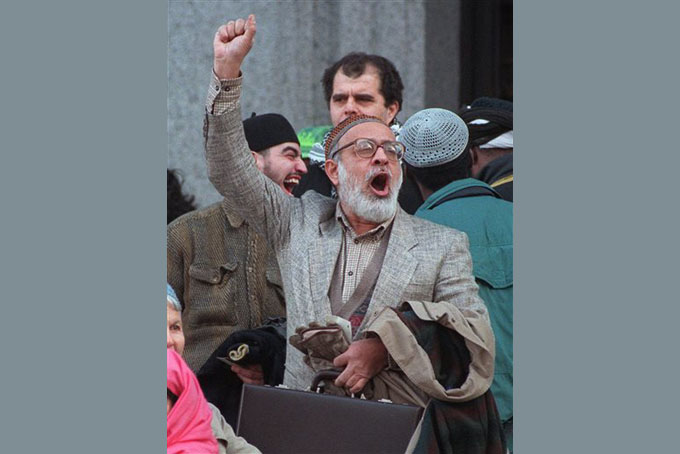 In this Jan. 17, 1996, file photo, Kaukab Siddique, center, raises his fist and shouts his support for Muslim cleric Sheikh Omar Abdel Rahman, outside the U.S. Courthouse in New York. Siddique, a tenured professor at Lincoln University in Pennsylvania, who previously questioned the Holocaust and called for Israel's destruction, is under fire again for incendiary remarks about Jews, women and gays. Lincoln University condemned Siddique's remarks but said it does not plan to take action against him. (AP Photo/Paul Hurschmann, File)