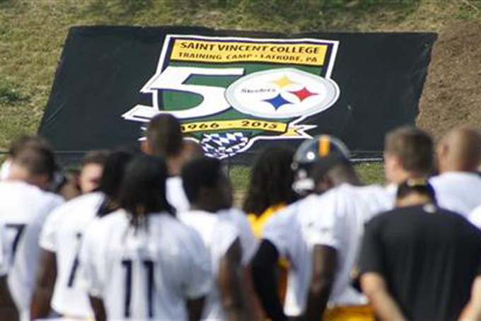 The Pittsburgh Steelers gather at midfield after their first practice at NFL football training camp under a banner on the hill marking their 50th year at the Saint Vincent College in Latrobe, Pa. on Sunday, July 26, 2015. (AP Photo/Keith Srakocic)