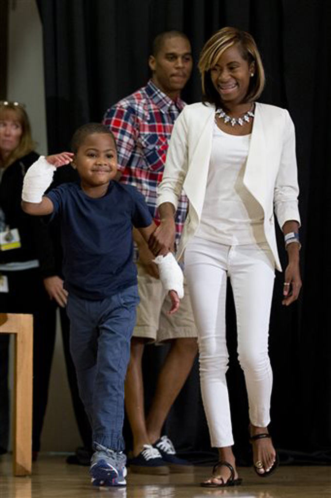 Double-hand transplant recipient eight-year-old Zion Harvey arrives to a news conference with his mother Pattie Ray Tuesday, July 28, 2015, at The Childrens Hospital of Philadelphia (CHOP) in Philadelphia. Surgeons said Harvey of Baltimore who lost his limbs to a serious infection,  has become the youngest patient to receive a double-hand transplant. (AP Photo/Matt Rourke)