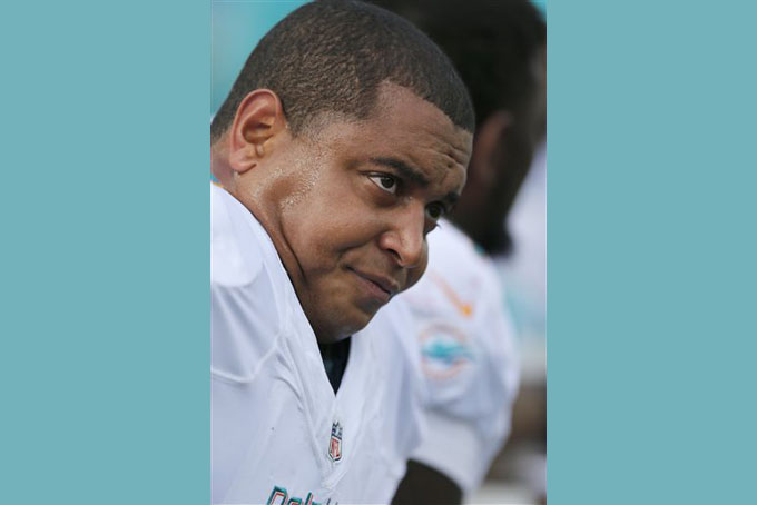 FILE - In this Oct. 27, 2013, file photo, Miami Dolphins tackle Jonathan Martin sits on the bench in the first quarter of an NFL football game against the New England Patriots, in Foxborough, Mass. Martin posted on Facebook that difficulties in the profession led him to attempt suicide multiple times, and he wanted to share his struggle with social isolation to help others. In his post Wednesday, Aug. 26, 2015, Martin referred to the Dolphinsí locker room situation with a profane synonym for "lousy." (AP Photo/Michael Dwyer, File))