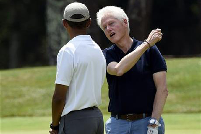 President Barack Obama, left, talks with former President Bill Clinton, center, as they play golf on the first hole at Farm Neck Golf Club in Oak Bluffs, Mass., on Martha's Vineyard, Saturday, Aug. 15, 2015. AP Photo/Susan Walsh)