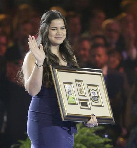 Daughter of Pro Football Hall of Fame inductee Junior Seau, Sydney Seau, waves after accepting a framed remembrance in place of her father's gold jacket during the Gold Jacket Ceremony in Canton, Ohio, Thursday, Aug. 6, 2015. (Scott Heckel/The Repository via AP)