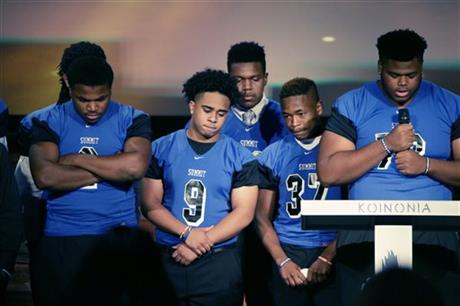 High school football teammates of Christian Taylor gather on stage during funeral services for Taylor at the Koinonia Christian Church in Arlington, Texas, Saturday, Aug. 15, 2015. The black college football player was fatally shot by a North Texas police officer answering a burglary call at a car dealership. Taylor was unarmed when he was fatally shot Aug. 7 by an Arlington police officer responding to an after-hours burglary call. The rookie police officer who shot the Angelo State University student was fired Tuesday. (AP Photo/LM Otero)