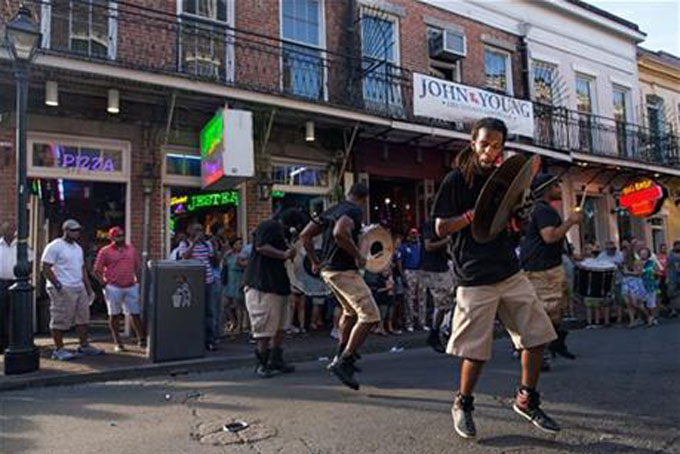 A percussion band performs for tourist dollars on Bourbon Street in the French Quarter of New Orleans, Saturday, Aug. 15, 2015. New Orleans is nearly three centuries old, mixing African-American, French, Spanish and Caribbean traditions to create unique forms of music, food and culture found nowhere else in America. (AP Photo/Max Becherer)