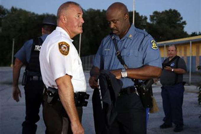 St. Louis County Police Chief Jon Belmar, left, and Highway Patrol Capt. Ronald Johnson confer, Monday, Aug. 10, 2015, in Ferguson, Mo. Ferguson was a community on edge again Monday, a day after a protest marking the anniversary of Michael Brown's death was punctuated with gunshots. (AP Photo/Jeff Roberson)