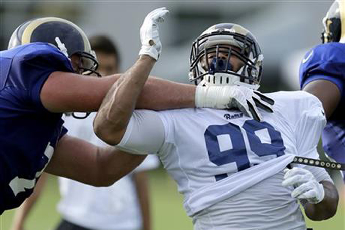 In this Aug. 6, 2015, file photo, St. Louis Rams defensive tackle Aaron Donald, right, tries to get around tackle Garrett Reynolds during training camp at the NFL football team's practice facility in St. Louis. Aaron Donald is not one to rest on his laurels. The NFC defensive rookie of the year for the St. Louis Rams knows there's lots of ways to improve. (AP Photo/Jeff Roberson, File)