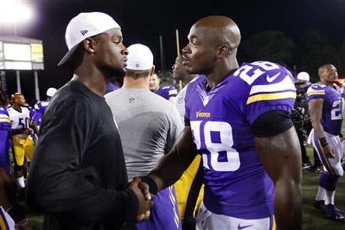 Minnesota Vikings running back Adrian Peterson, right, visits with Pittsburgh Steelers running back Le'Veon Bell, left, on the field after an NFL preseason football game in Canton, Ohio, Sunday, Aug. 9, 2015. The Vikings won 14-3. (AP Photo/Tom E. Puskar)