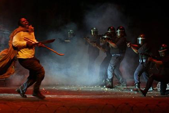In this photo taken Thursday, Aug. 13, 2015 actors, re-enact the scene when police, right, open fire on striking platinum mineworkers, in the musical "Marikana" in Pretoria, South Africa. South Africans sing and dance when they mourn, which is why a musical is a fitting way to commemorate the police shootings of striking miners three years ago, says the lead actor of “Marikana - The Musical.” On Aug. 16 2012, a weekslong labor dispute reached a bloody climax as police opened fire and killed 34 miners in Marikana, a mining town in the North West province. Mavuso Magabane plays the leader of the strike who was killed in the shootings that were the largest loss of life in a police operation since South Africa achieved majority rule in 1994. (AP Photo/Themba Hadebe)