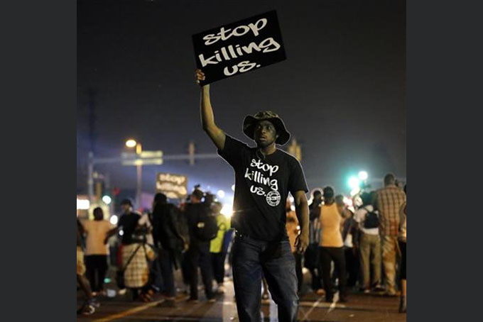  In this Aug. 18, 2014, file photo, protesters walk through the streets after a standoff with police in Ferguson, Mo. A year ago, most Americans had never heard of the St. Louis suburb called Ferguson. But after a white police officer fatally shot a black 18-year-old in the street, the name of the middle-class community quickly became known around the world. (AP Photo/Charlie Riedel, File)