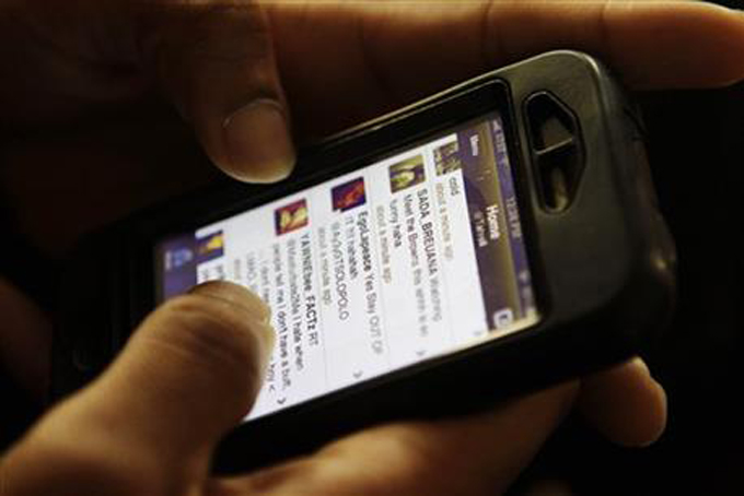 TECHED OUT--In this Jan. 5, 2011, file photo, Tyrell Coley, 21, holds his iPhone displaying his Twitter account in the Queens borough of New York. (AP Photo/Frank Franklin II)