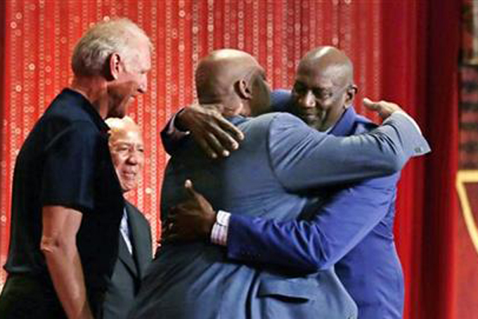 Basketball Hall of Fame inductee Spencer Haywood, right, embraces former NBA player Charles Barkley during the enshrinement ceremony for the Class of 2015 of the Naismith Memorial Basketball Hall of Fame in Springfield, Mass., Friday, Sept. 11, 2015. At left are former player Bill Walton and coach Lenny Wilkens. (AP Photo/Charles Krupa)