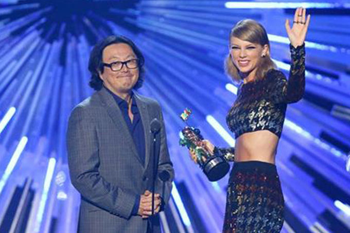 FILE - In this Aug. 30, 2015 file photo, director Joseph Kahn, left, and Taylor Swift appear on stage as Swift accepts the award for female video of the year for “Blank Space” at the MTV Video Music Awards in Los Angeles. Kahn, the director of Swift’s new music video is defending the singer after some claimed she whitewashed her video based in Africa. He said in a statement Wednesday, Sept. 2, that the video for “Wildest Dreams” includes black people and was produced by a black woman and edited by a black man. (Photo by Matt Sayles/Invision/AP, File)