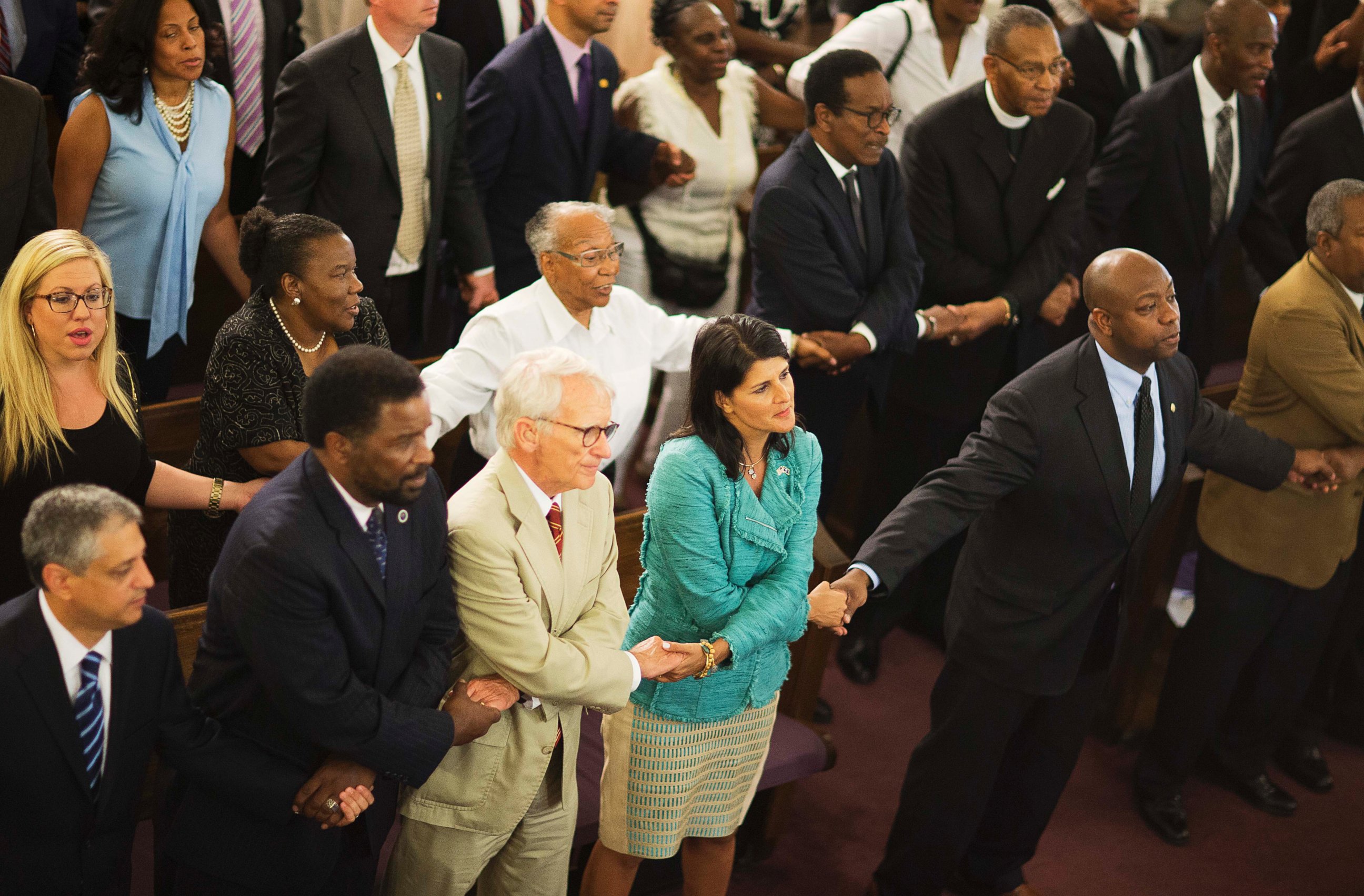 .C. Gov. Nikki Haley, center right, joins hands with Charleston Mayor Joseph Riley, left, and Sen. Tim Scott, right, at a memorial service at Morris Brown AME Church for the people killed during a prayer meeting inside Emanuel African Methodist Episcopal Church in Charleston, S.C. on June 18, 2015.  (David Goldman/AP Photo)