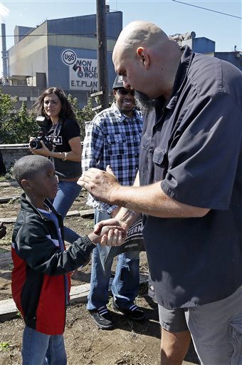John Fetterman, right, the mayor of Braddock, Pa., shakes hands with a young supporter while announcing his candidacy for the U.S. Senate, Monday, Sept. 14, 2015, in Braddock. (AP Photo/Keith Srakocic)