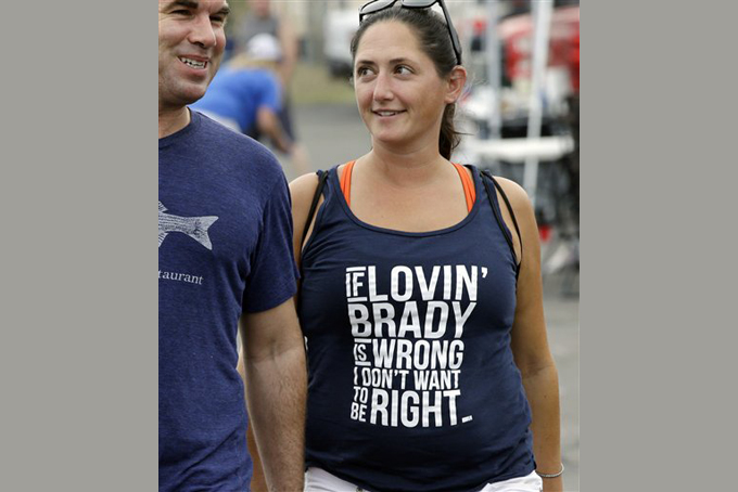 Kate Lyons wears a shirt referring to Patriots quarterback Tom Brady as she walks with Josh Mailloux before an NFL preseason football game between the Patriots and the New York Giants Thursday, Sept. 3, 2015, in Foxborough, Mass. Federal Judge Richard M. Berman overturned NFL Commissioner Roger Goodell's four-game suspension of New England quarterback Tom Brady Thursday morning. The league said it will appeal the ruling. (AP Photo/Stephan Savoia)