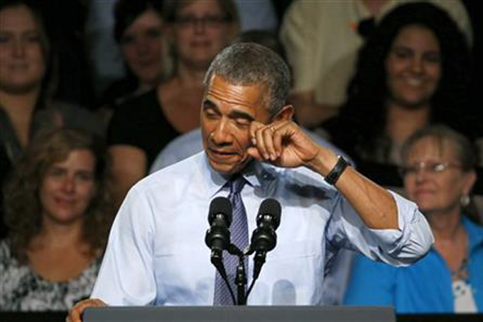 President Barack Obama pretends to wipe a tear during his speech at Macomb County Community College Wednesday, Sept. 9, 2015, in Warren, Mich. The president said he's "a little freaked out" that his oldest daughter, Malia, just started her senior year in high school. (AP Photo/Paul Sancya)