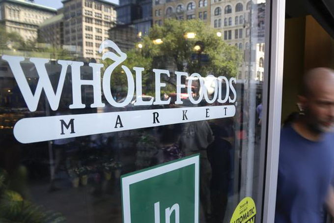 A shopper leaves a Whole Foods Market in New York in June. (Julie Jacobson / Associated Press)