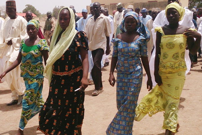 AREUNITED—In this April 21, 2014 file photo, four female students of the government secondary school Chibok, who were abducted by gunmen and reunited with their families, walk in Chibok, Nigeria. (AP Photo/ Haruna Umar, File)
