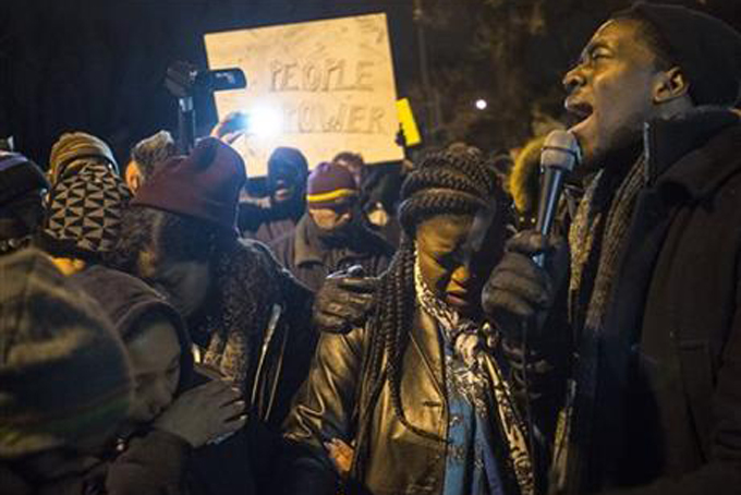 NAACP Youth Director Stephen Green sings "We Shall Overcome" at a makeshift memorial for Jamar Clark near Plymouth Avenue, Friday, Nov. 20, 2015, in Minneapolis. Clark was fatally shot by police on Sunday. (Aaron Lavinsky/Star Tribune via AP) 