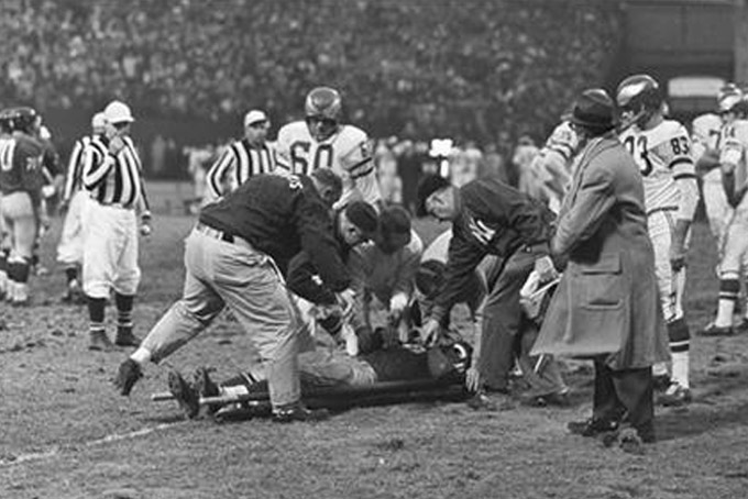 In this Nov. 20, 1960, file photo, Chuck Bednarik (60) of the Philadelphia Eagles looks on as Frank Gifford of the New York Giants is put on a stretcher in the last quarter of a football game at Yankee Stadium in New York. The Eagles' Bobby Walston (83) is at right. Gifford was carried off the field unconscious and rushed to a hospital where he was reported to have a severe concussion. (AP Photo/Harry Harris, File)