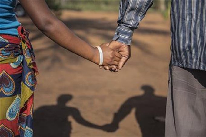 CHILD-BRIDE--In this photo taken Wednesday, Nov. 18, 2015 a 15-year-old pregnant girl holds hands with her 20-year-old husband-to-be in Guibombo, some 40 kilometers from the city of Inhambane, Mozambique. (AP Photo/Shiraaz Mohamed)