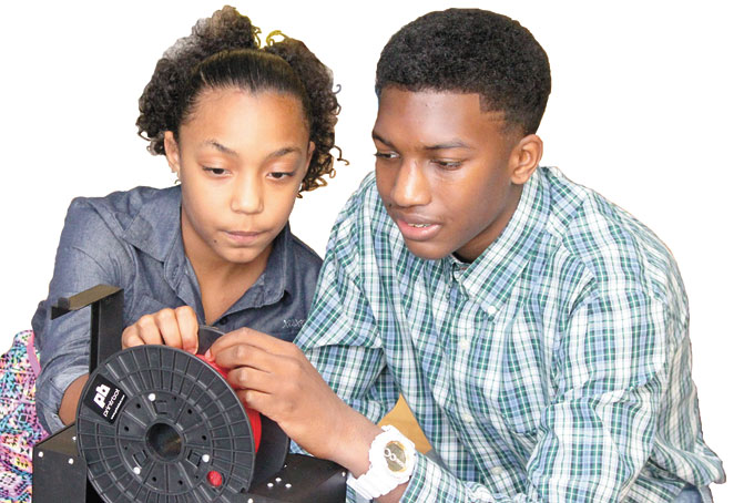 STEM WARRIOR—Quincy Stanley, right, works with his cousin, Trinity Stanley, on STEM activities using a 3D printer at Pittsburgh Arsenal 6-8. (Photo by Jacquelyn McDonald for New Pittsburgh Courier)