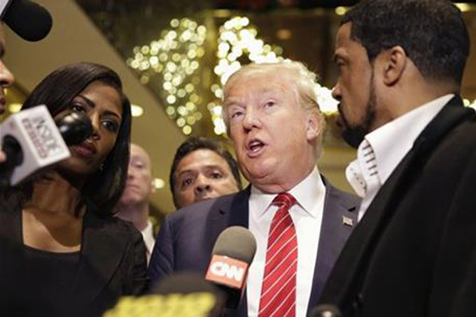 Republican Presidential candidate Donald Trump, center, talks with reporters while surrounded by a group of African-American religious leaders in New York, Monday, Nov. 30, 2015. Trump met with a coalition of 100 African-American evangelical pastors and religious leaders in a private meeting at Trump Tower. (AP Photo/Seth Wenig)