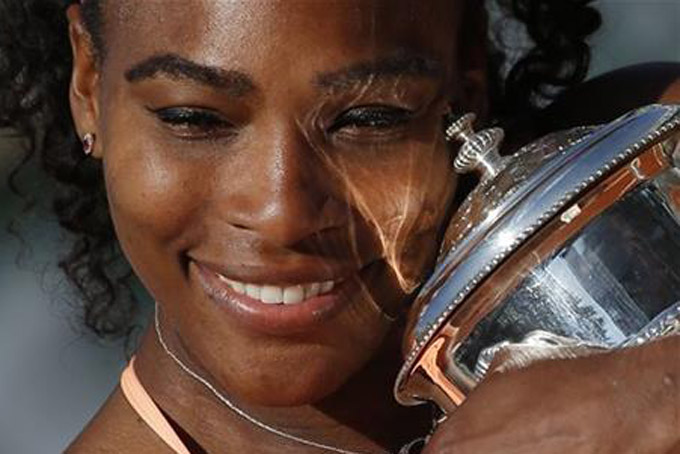 In this June 6, 2015, file photo, Serena Williams, of the United States, holds the trophy after winning the final of the French Open tennis tournament against Lucie Safarova, of the Czech Republic, at the Roland Garros stadium, in Paris. For the fourth time, Williams has been named The Associated Press Female Athlete of the Year. (AP Photo/Michel Euler, File)