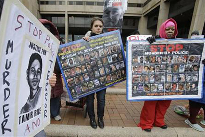 People protest outside the Cuyahoga County Justice Center, Tuesday, Dec. 29, 2015, in Cleveland. People marched peacefully in front of the Justice Center in downtown Cleveland to protest a grand jury's decision not to indict two white Cleveland police officers in the fatal shooting of Tamir Rice, a black 12-year-old boy who was playing with a pellet gun. (AP Photo/Tony Dejak)