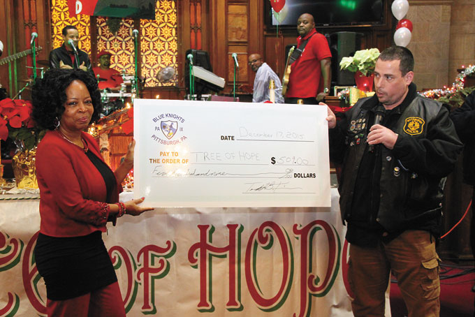 DONATION FROM THE HEART—After learning of Tree of Hope's efforts, the Pittsburgh Chapter of the Blue Knight International Law Enforcement Motorcycle Club Inc. made a sizeable donation. Detective Todd Trivus, right, presents Adrienne Young the check on behalf of his group. (Photos by Jackie McDonald)